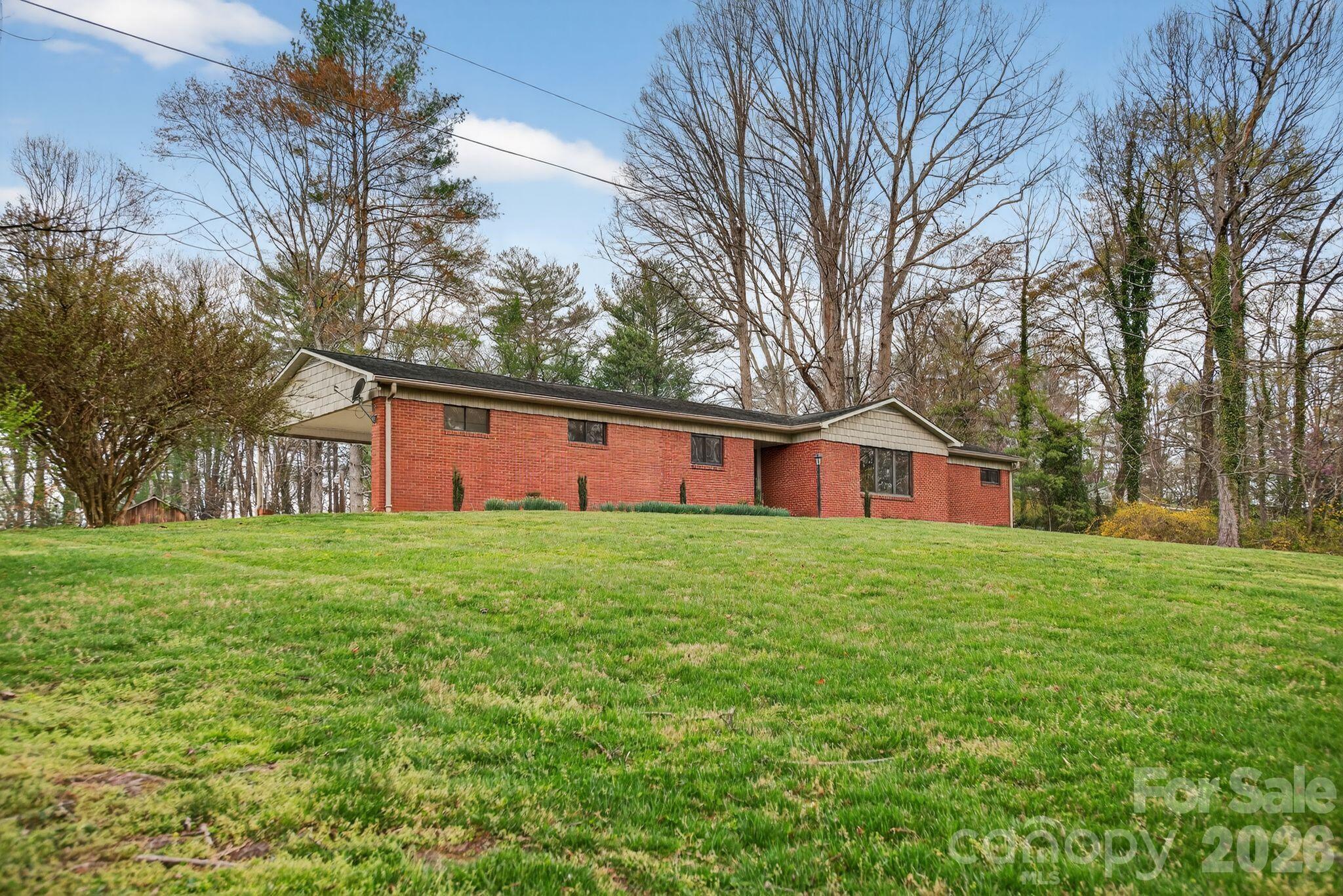 4783 Calico Road Lenoir, NC 28645 - Photo 4 of 44 a view of a yard in front of a house with large trees