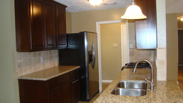 a kitchen with a sink a refrigerator and cabinets