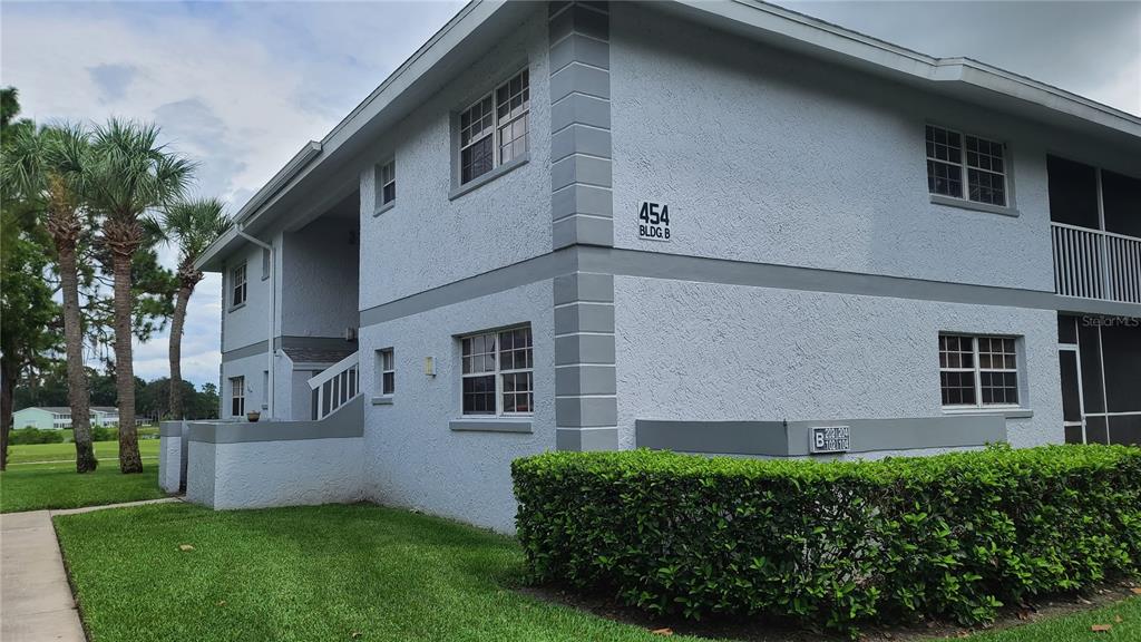 454 Fairways Circle, Unit B102 Ocala, FL 34472 - Photo 1 of 7 a front view of a house with a garden