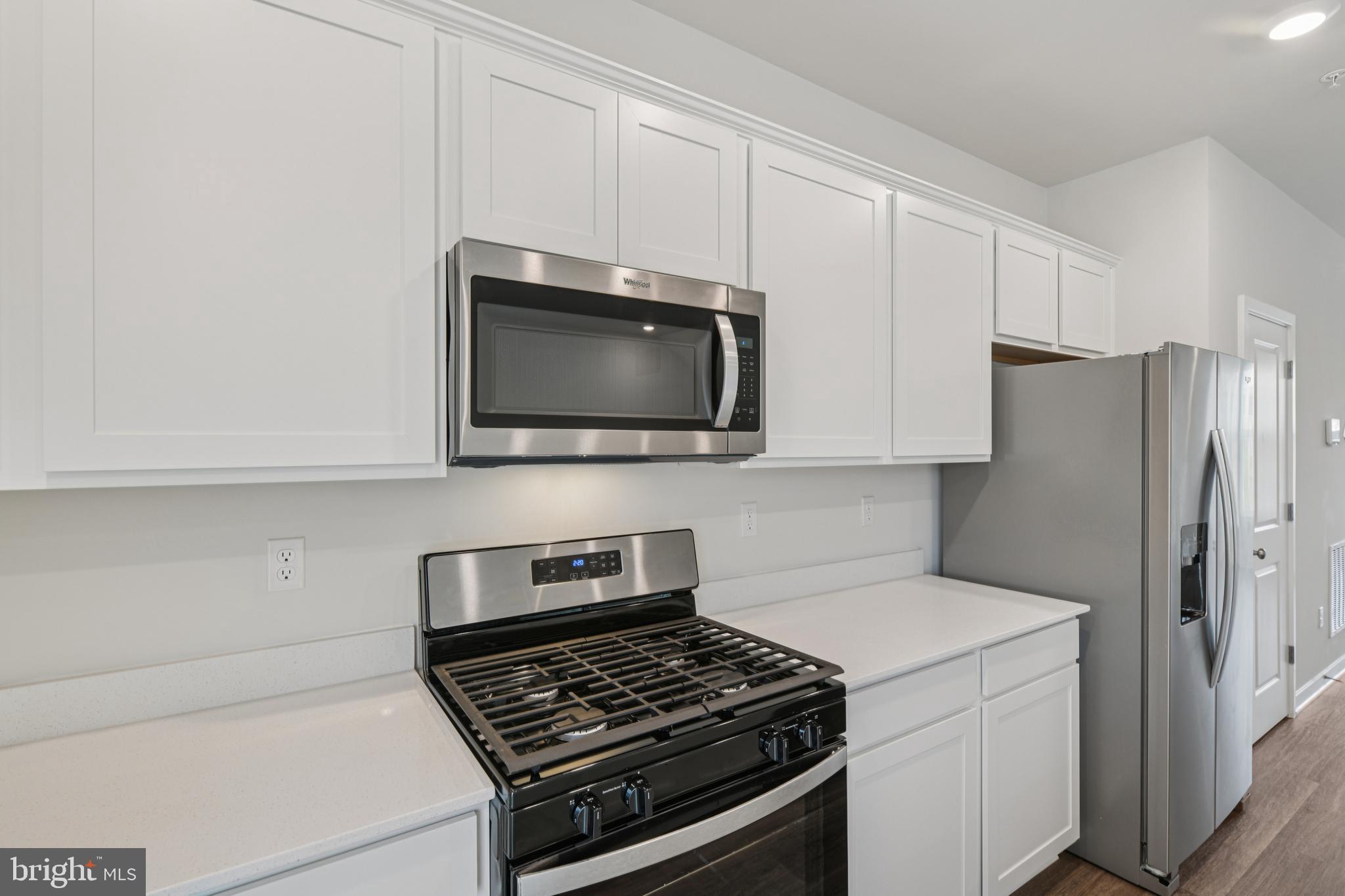 7406 Calm Retreat Boulevard Brandywine, MD 20613 - Photo 11 of 37 a kitchen with a stove and a microwave