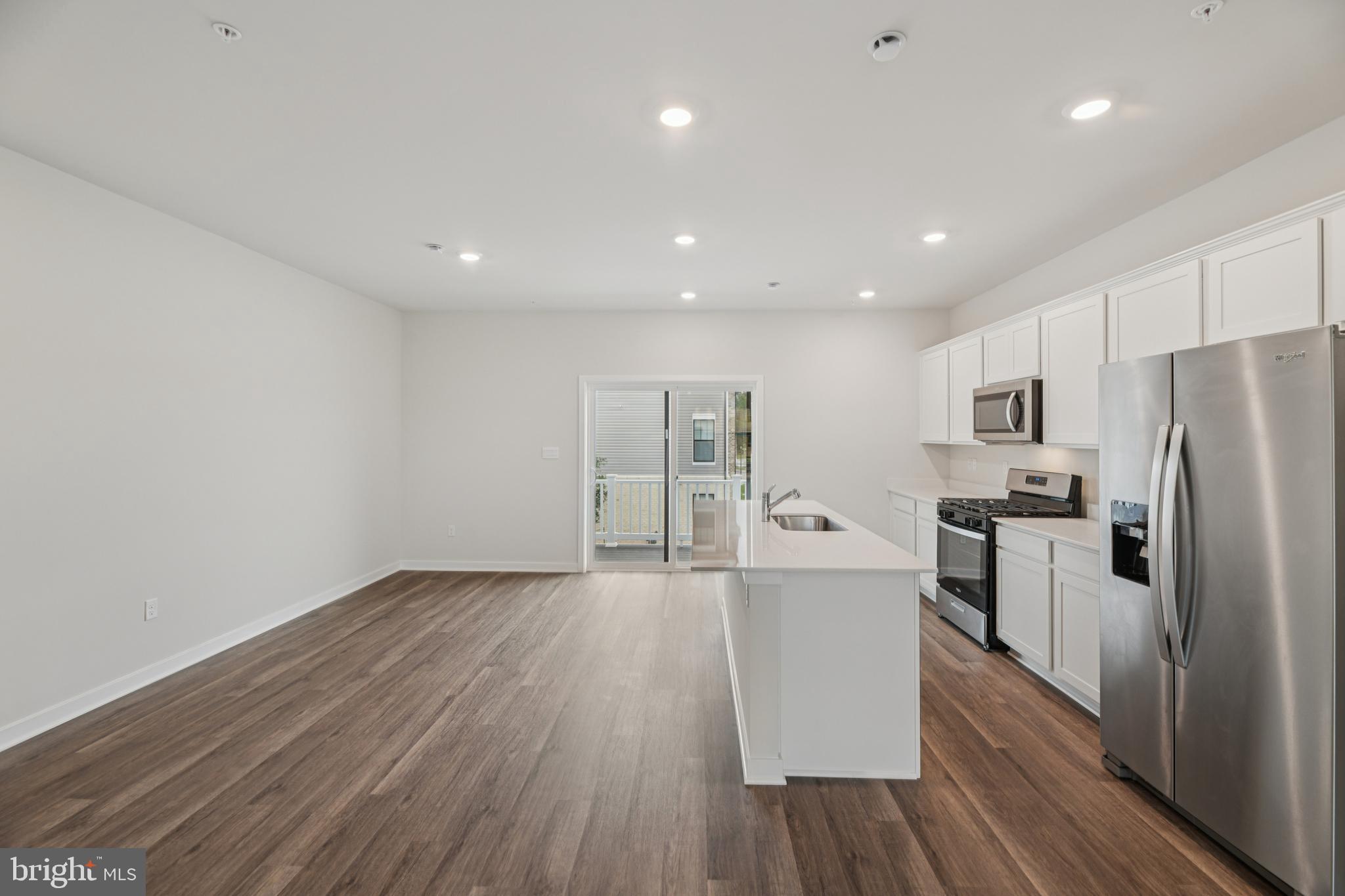 7406 Calm Retreat Boulevard Brandywine, MD 20613 - Photo 13 of 37 a large kitchen with a wooden floor and stainless steel appliances