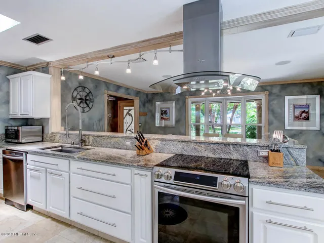 a kitchen with stainless steel appliances a refrigerator and a window