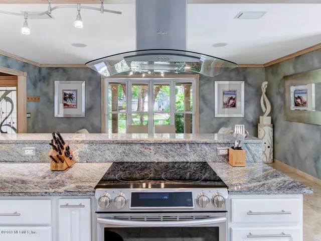 a kitchen with stainless steel appliances granite countertop a sink and a stove next to a white refrigerator