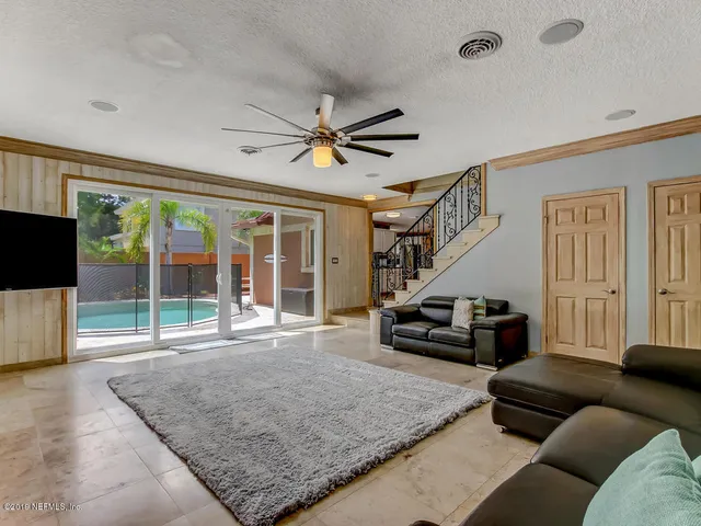 a dining room with furniture a chandelier and wooden floor