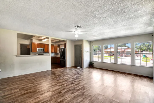 a view of a big room with wooden floor windows and chandelier