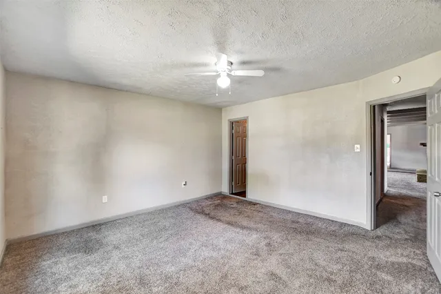 an empty room with fan and a ceiling fan
