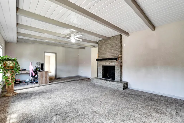 a view of empty room with fireplace and fan