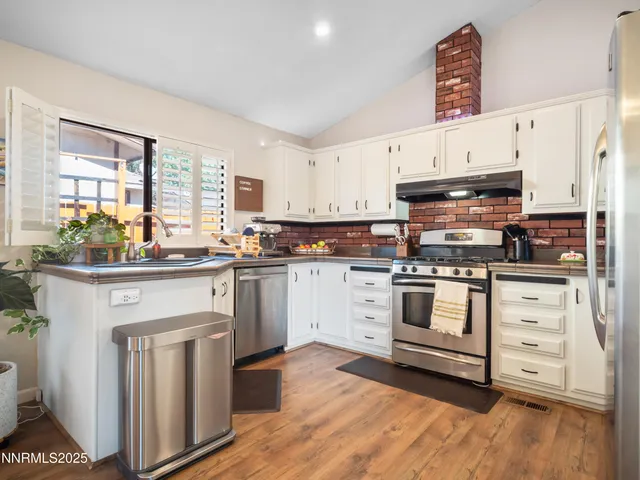 a kitchen with granite countertop white cabinets and white appliances