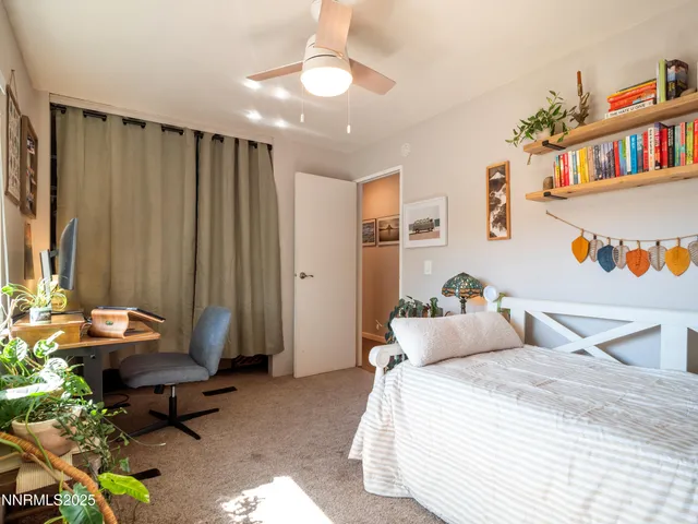 a bedroom with a bed a bookshelf and a window
