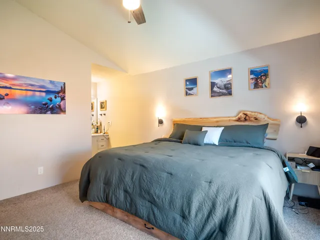 a bedroom with a bed and a lamp on the dresser