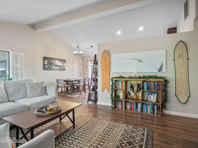 a living room with furniture a rug and a book shelf