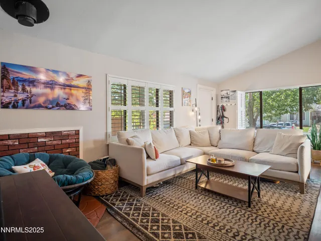 a living room with furniture and a floor to ceiling window