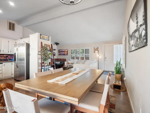 a room with stainless steel appliances furniture a large window and a kitchen view