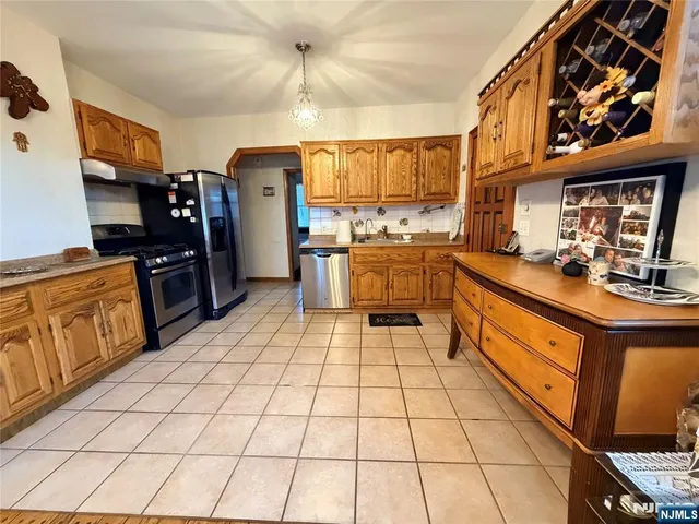 a kitchen with stainless steel appliances a sink cabinets and wooden floor