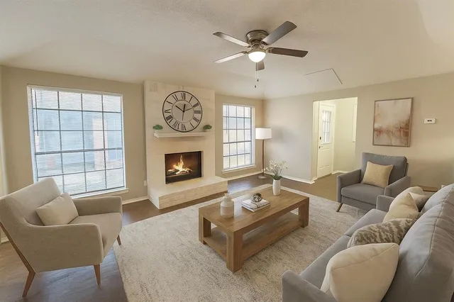 a living room with furniture a fireplace and a large window