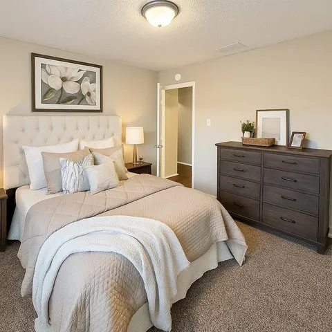 a bedroom with a bed and a painting on the wall