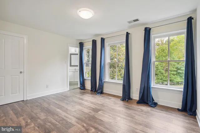 a view of an empty room with glass door and balcony