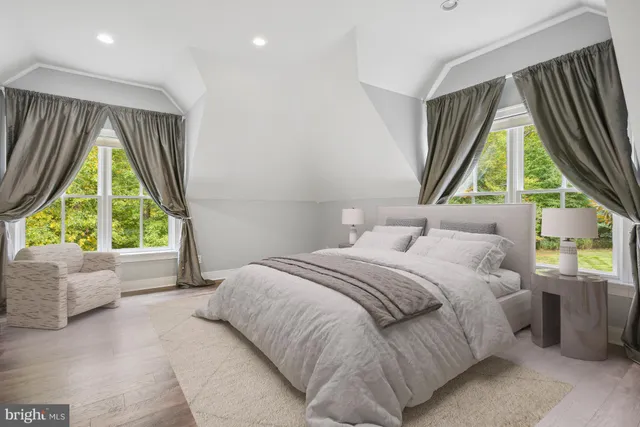 a bedroom with a bed and a large window