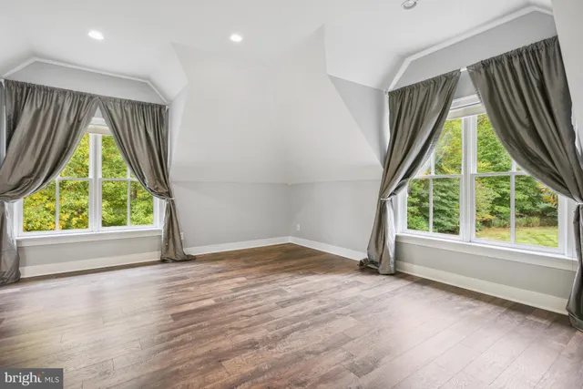 an empty room with window wooden floor and outdoor view