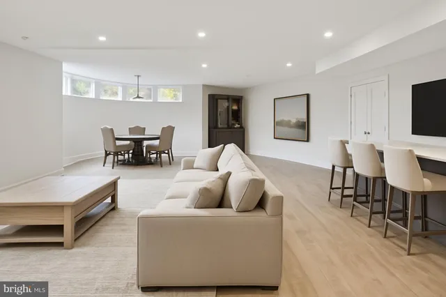 a living room with furniture and a dining table with wooden floor