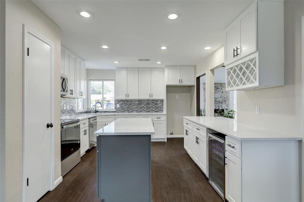 a large kitchen with stainless steel appliances lots of white cabinets