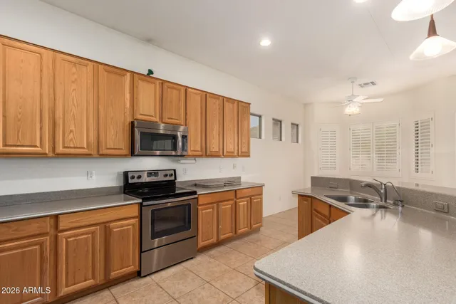 a kitchen with stainless steel appliances granite countertop a sink a stove and cabinets