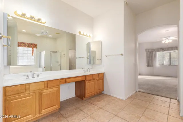 a large bathroom with a double vanity sink a large mirror and a bathtub