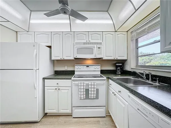 a kitchen with stainless steel appliances granite countertop a sink and a refrigerator
