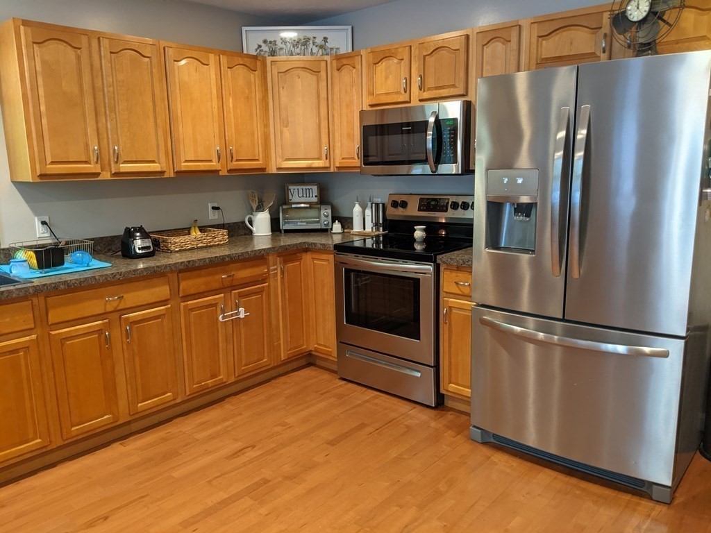 1230 Bemis Road Warren, MA 01083 - Photo 3 of 17 a kitchen with stainless steel appliances granite countertop a refrigerator stove a sink and dishwasher with wooden floor