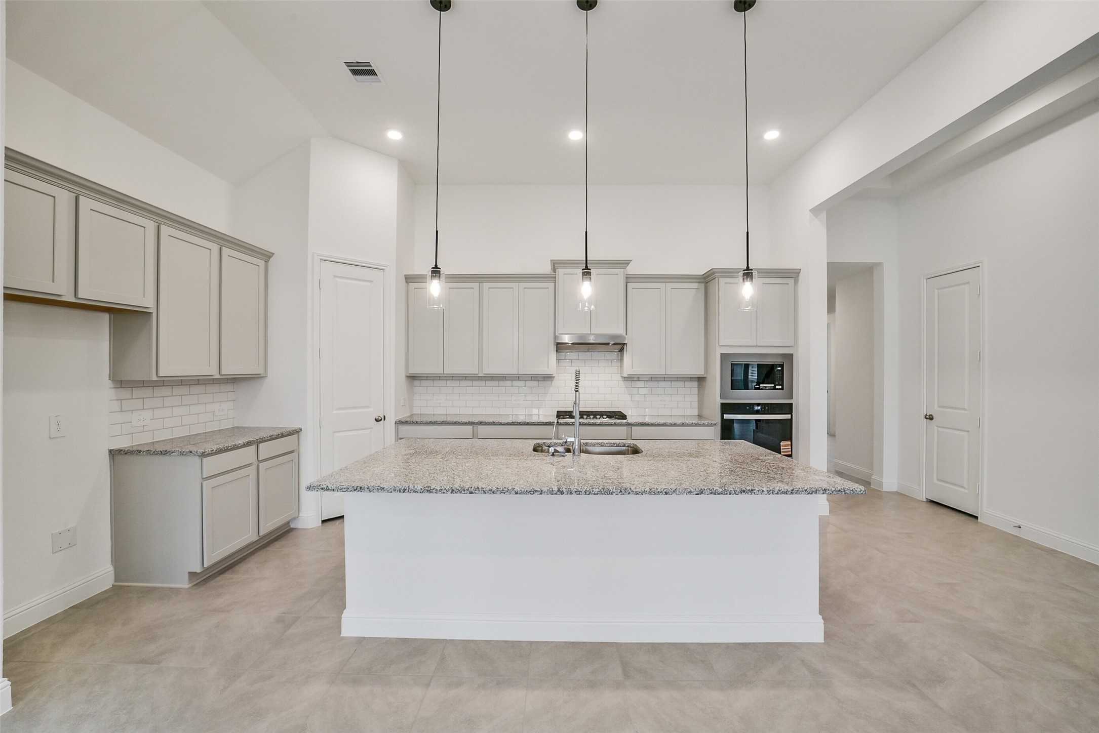 16018 Tangled Vine Lane Conroe, TX 77302 - Photo 11 of 41 a large kitchen with kitchen island a stove a sink a center island a stove and a cabinets