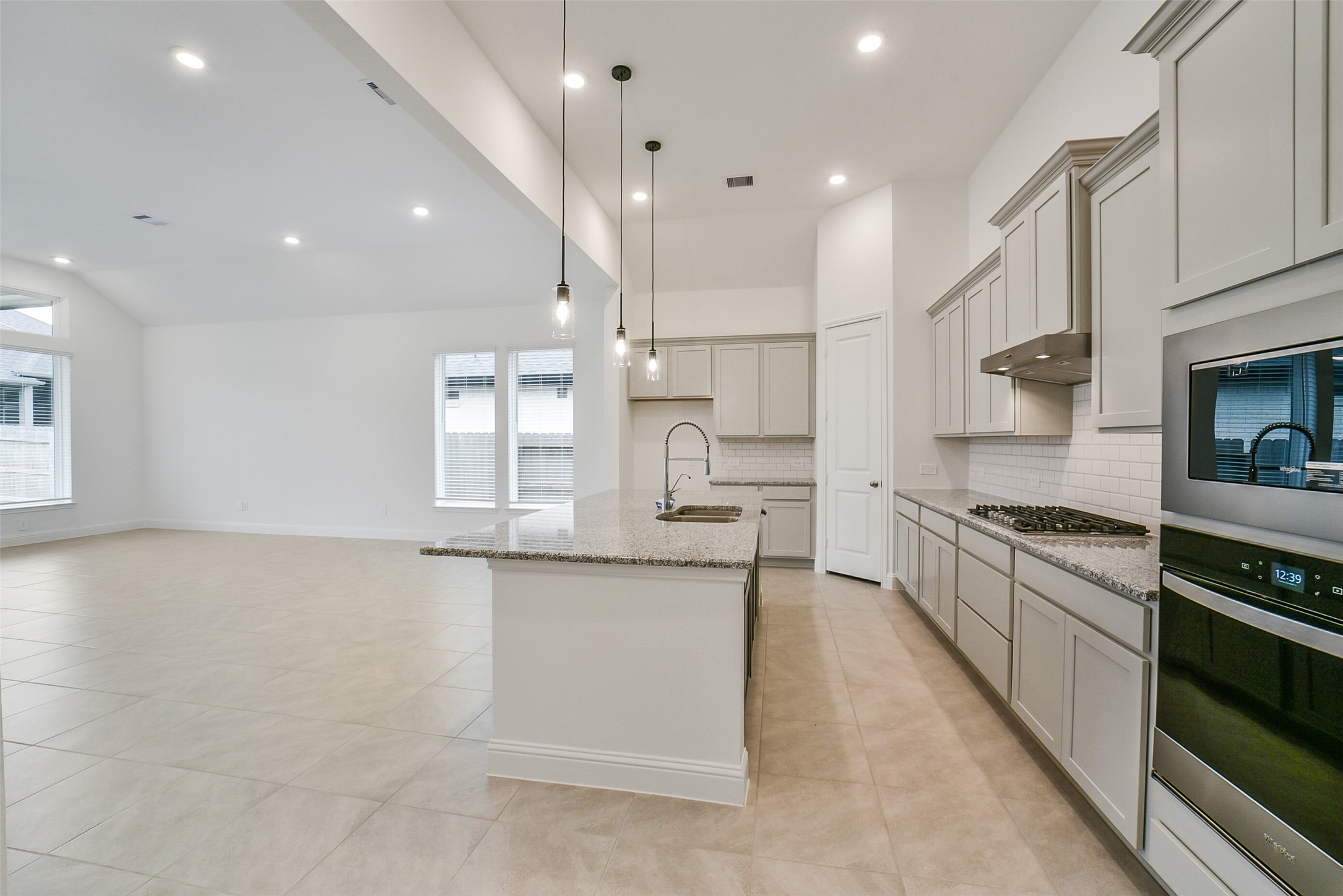 16018 Tangled Vine Lane Conroe, TX 77302 - Photo 16 of 41 a large kitchen with stainless steel appliances granite countertop a stove a sink and a refrigerator