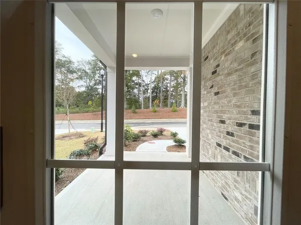 a view of a room with a large window and wooden floor