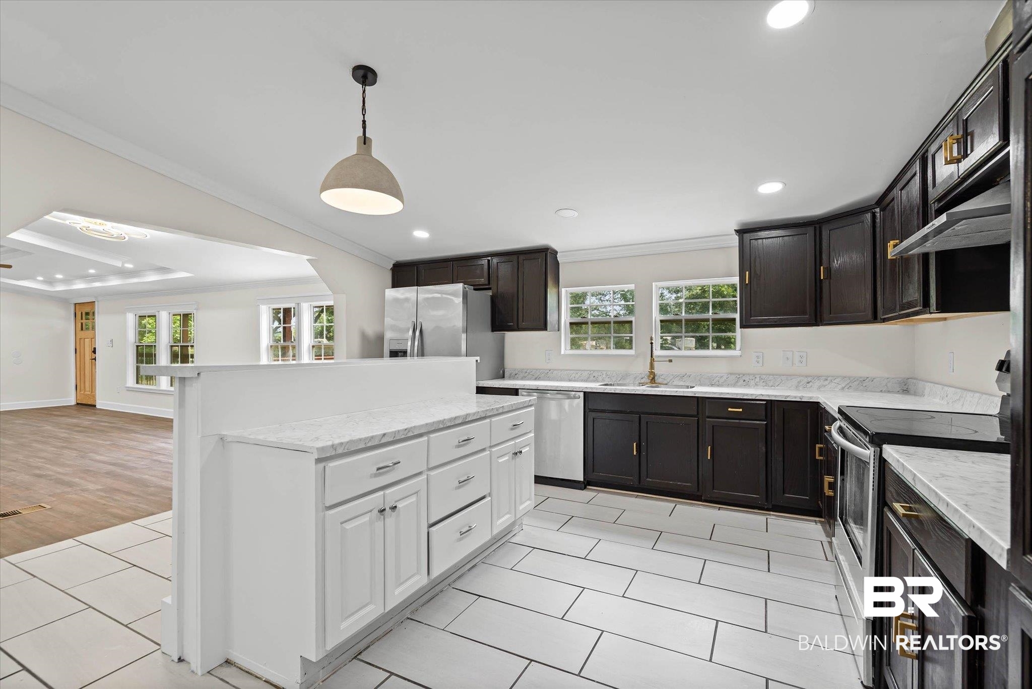 9230 McLeod Road Mobile, AL 36695 - Photo 9 of 20 Contemporary kitchen featuring dark wood cabinetry, light-toned countertops, and stainless steel appliances