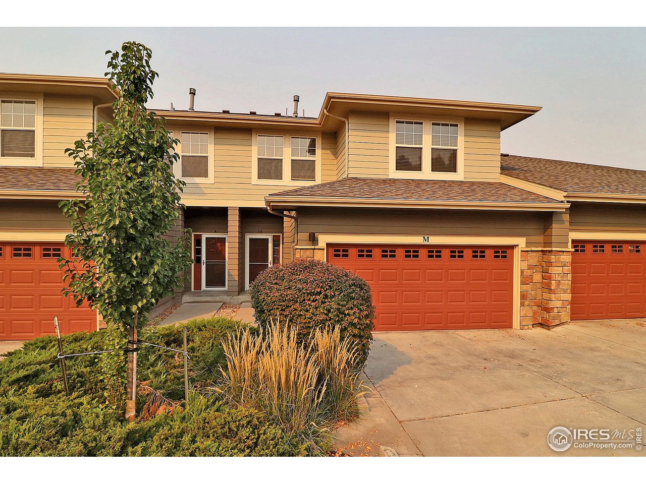 5600 West 3rd Street, Unit 4 Greeley, CO 80634 - Photo 1 of 32 a front view of a house with a yard and garage
