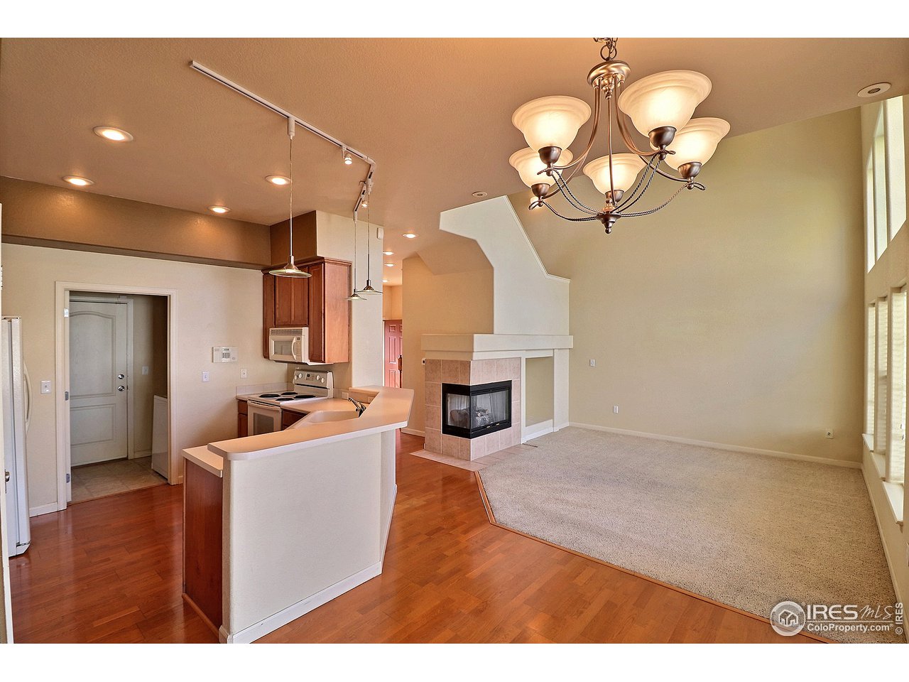 5600 West 3rd Street, Unit 4 Greeley, CO 80634 - Photo 12 of 32 a view of a livingroom with a fireplace a chandelier and wooden floor