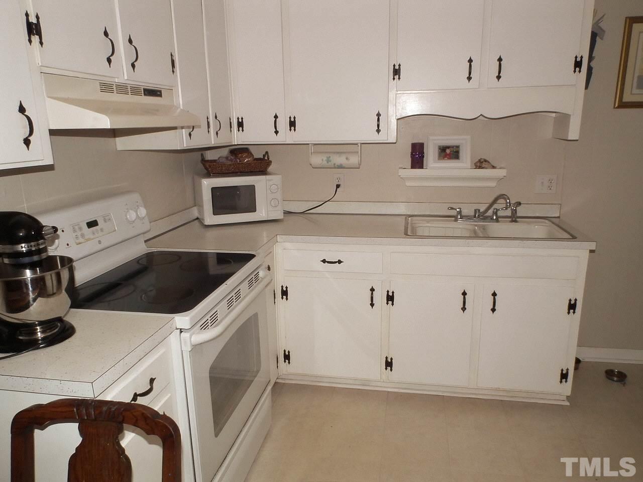 2824 Oak Ridge Court Raleigh, NC 27603 - Photo 2 of 22 a kitchen with white cabinets and white appliances