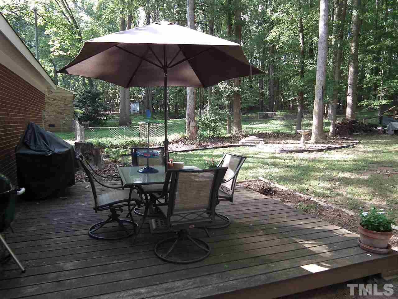 2824 Oak Ridge Court Raleigh, NC 27603 - Photo 15 of 22 a view of a patio with table and chairs under an umbrella