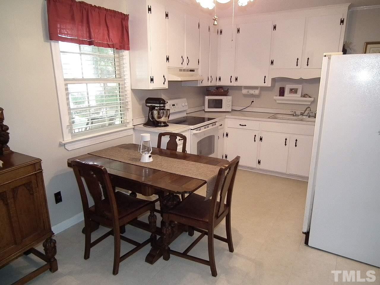 2824 Oak Ridge Court Raleigh, NC 27603 - Photo 4 of 22 a view of kitchen with dining table chairs and refrigerator