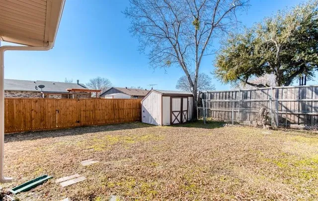 a backyard of a house with wooden fence and a bench