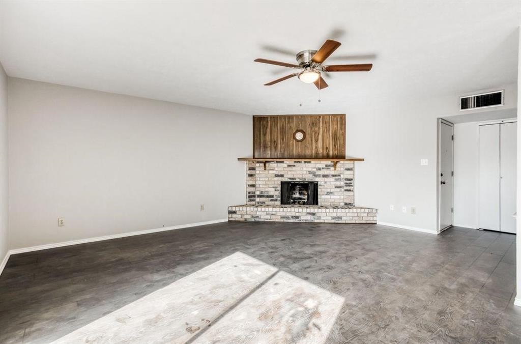 5656 Pearce Street The Colony, TX 75056 - Photo 2 of 23 a view of a livingroom with a fireplace and a ceiling fan