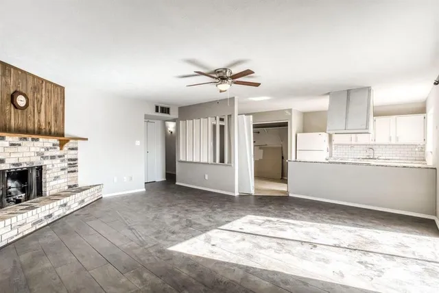 a view of a kitchen with an empty room and fire place