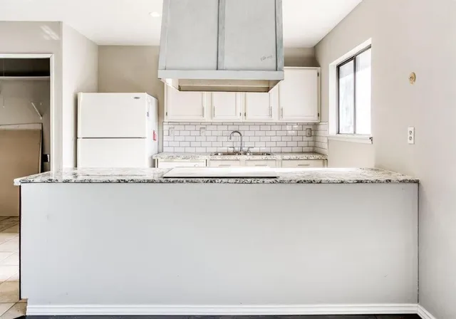 a kitchen with granite countertop a sink and a stove