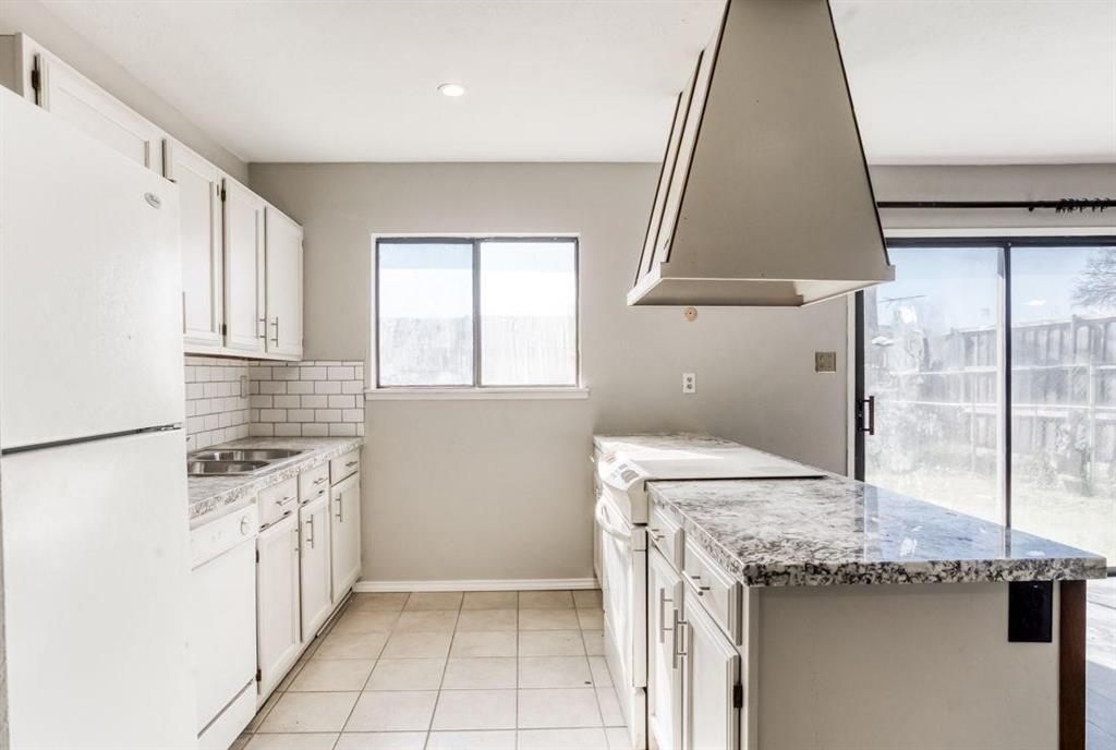 5656 Pearce Street The Colony, TX 75056 - Photo 6 of 23 a kitchen with a sink stove and cabinets
