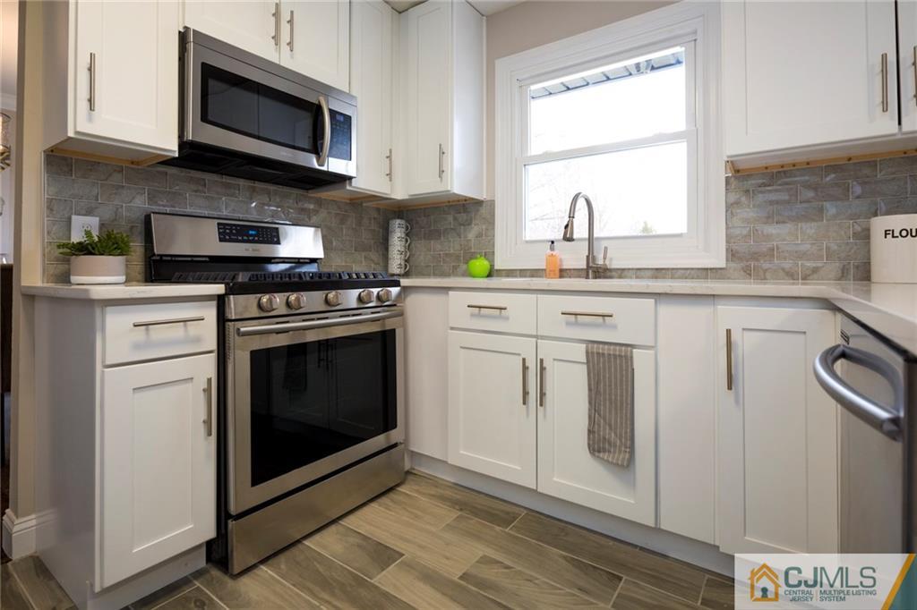 66 Middlesex Road Matawan, NJ 07747 - Photo 12 of 22 a kitchen with white cabinets stainless steel appliances and sink