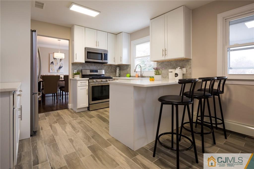 66 Middlesex Road Matawan, NJ 07747 - Photo 9 of 22 a kitchen with stainless steel appliances granite countertop a stove top oven a sink dishwasher and a refrigerator with wooden floor