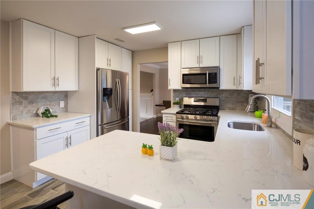 66 Middlesex Road Matawan, NJ 07747 - Photo 10 of 22 a kitchen with a refrigerator a stove a microwave and cabinets