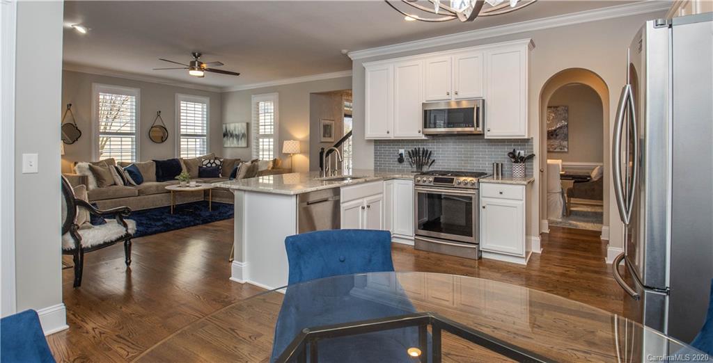728 Shady Grove Crossing Fort Mill, SC 29708 - Photo 12 of 41 a kitchen with stainless steel appliances granite countertop a stove top oven a sink dishwasher a dining table and chairs with wooden floor