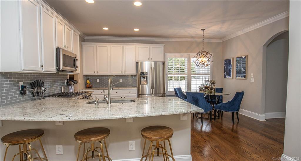 728 Shady Grove Crossing Fort Mill, SC 29708 - Photo 9 of 41 a kitchen with granite countertop kitchen island stainless steel appliances a dining table chairs sink and cabinets