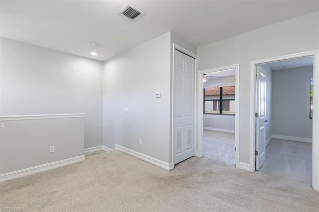 an empty room with closet and mirrors