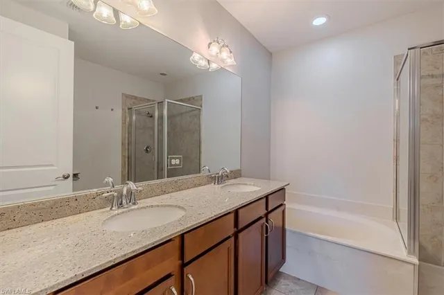 a bathroom with a granite countertop sink a mirror and a bathtub